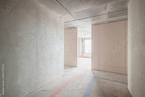 Wallpaper Mural unfinished room under construction, featuring bare concrete walls, a ceiling with exposed wiring, and marked floor lines. The space is minimalist and industrial in feel Torontodigital.ca