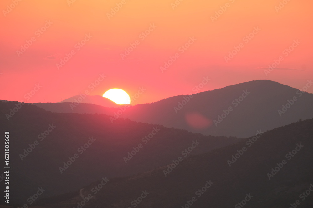 Obraz premium Sun setting behind mountains