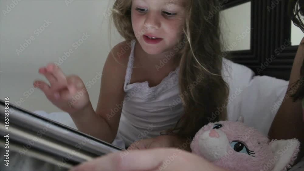 Little Girl Using Tablet While Sitting in Bed Little Girl Using Tablet While Sitting in Bed