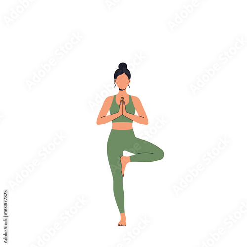 A woman in green sportswear practices the Tree Pose yoga asana, balancing on one leg with her hands in prayer.