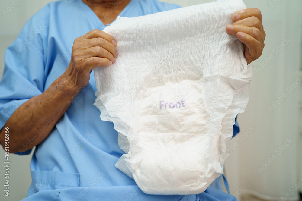 Fototapeta premium Asian senior woman patient wearing adult incontinence diaper pad in hospital.