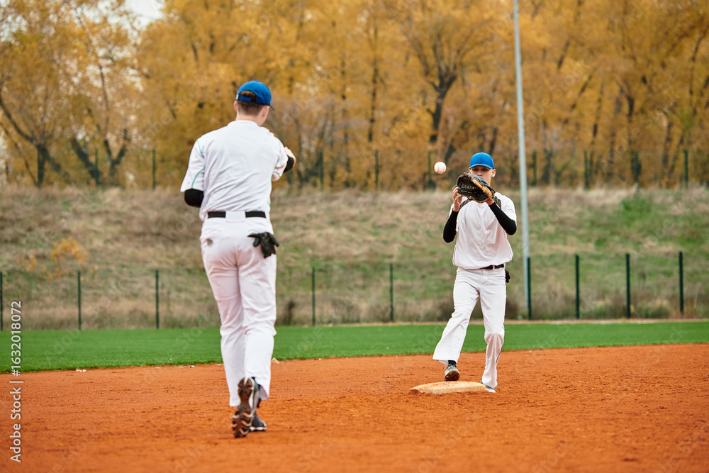 Two teenage boys engage in a spirited baseball practice on a vibrant autumn field Two teenage boys engage in a spirited baseball practice on a vibrant autumn field