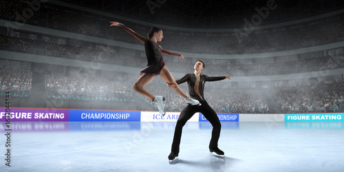Figure skating couple skating on ice stadium.