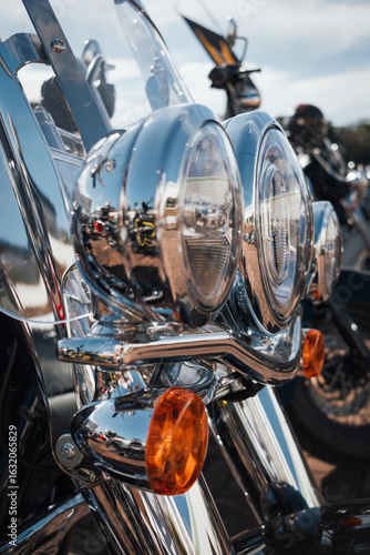 Fotomural Harley-Davidson custom motorcycle headlight assembly, consisting of dual circular chrome headlights on exhibition at Motor Rock event for custom motorcycles