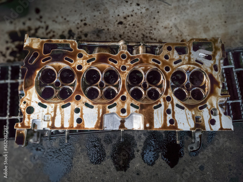 combustion chamber in the cylinder head of a gasoline engine vehicle being overhauled in a garage	