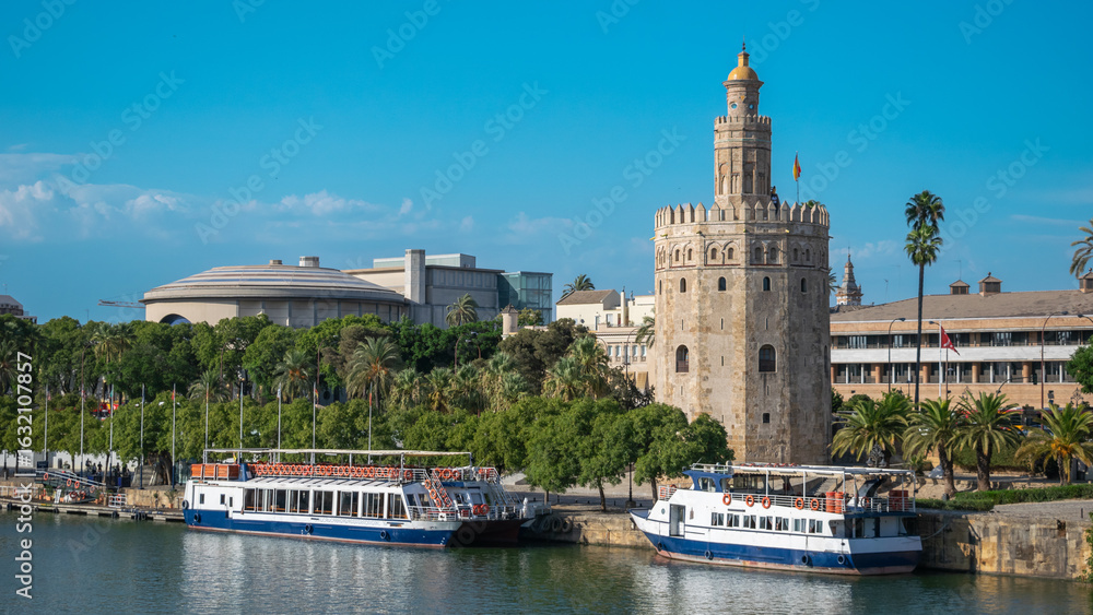 Fototapeta premium La historica torre del oro siglo XIII a orillas del rio Guadalquivir con barcos de recreo en la ciudad de Sevilla, España