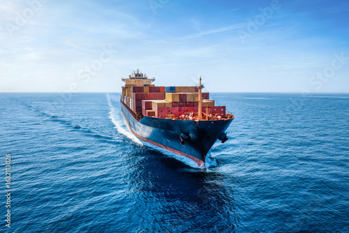 Aerial front view of a industrial container cargo ship traveling over the calm ocean