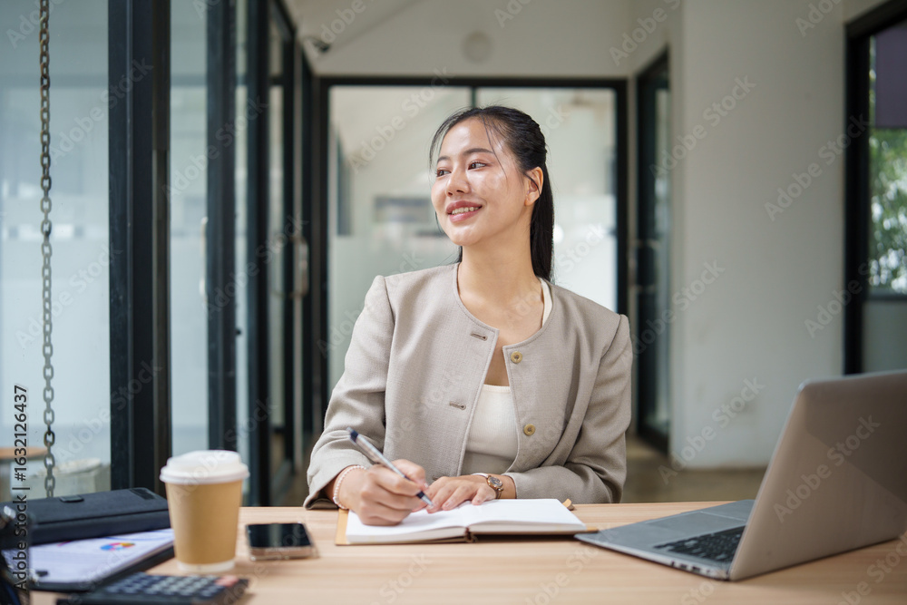Confident female executive thinking creatively during work in a contemporary workspace. Confident female executive thinking creatively during work in a contemporary workspace.