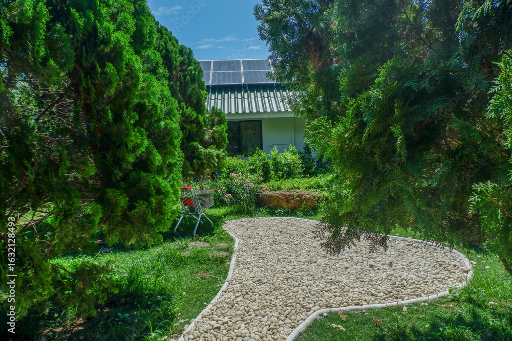Naklejka premium Solar panel on a roof reflecting the sun and blue sky,photovoltaic panels on the roof,Roof Of solar cell with sunlight and view small garden in forest.