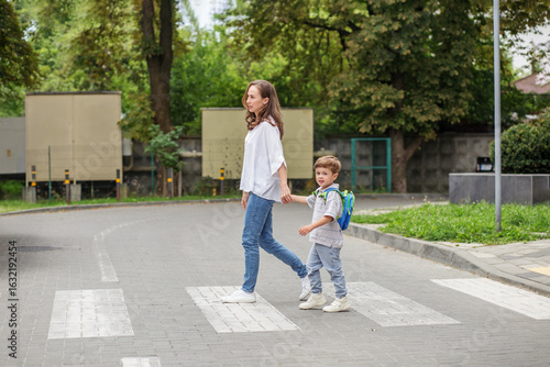 Mother and son crossing street hand in hand. Back to school.