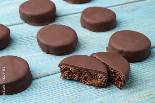 Brazilian Pao de Mel or chocolate covered honey cookies over a blue wooden table