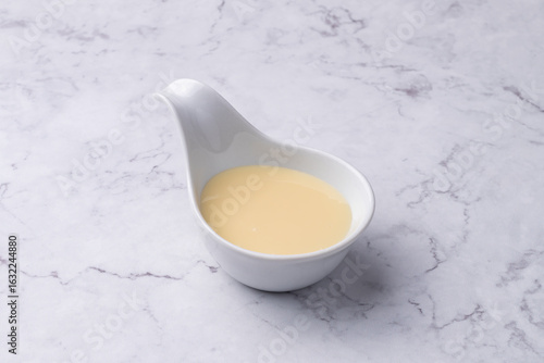 Condensed milk in a bowl over marble table