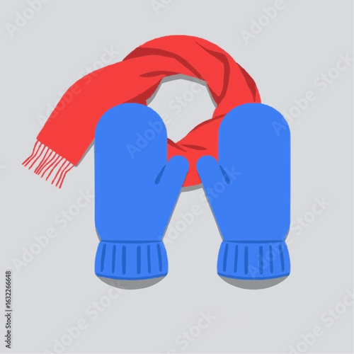 Blue mittens and red scarf on grey background  
