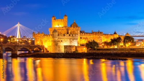 Wallpaper Mural A nighttime view of a grand, illuminated castle near water, with a modern bridge and an old arch bridge visible. The water reflects the castle's glow Torontodigital.ca