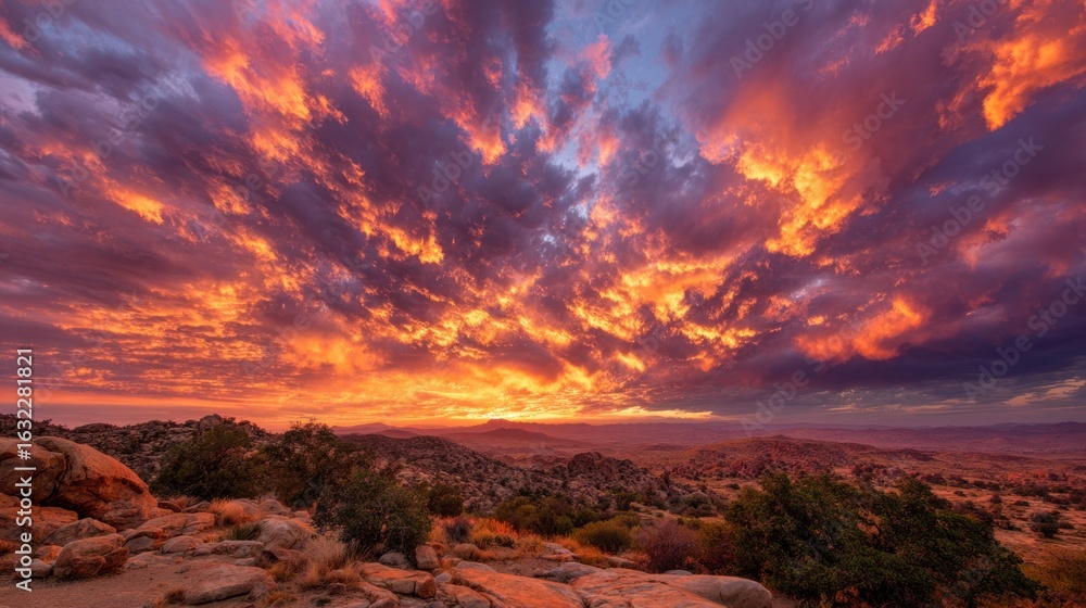 Fototapeta premium Fiery sunset clouds over desert landscape