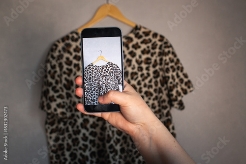 Woman taking photo of her old clothes for resale. Second hand concept. Closet organization.
