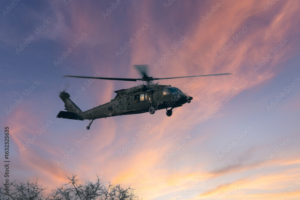 Fototapeta premium Military Aircraft in Flight, A military transport aircraft flying against a bright blue sky, captured from below during its flight.
