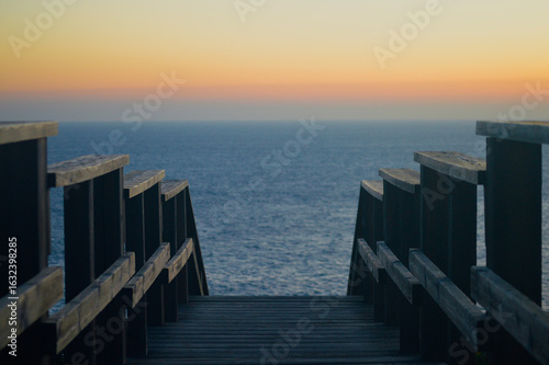 Escaleras de madera para ver el atardecer en el mar