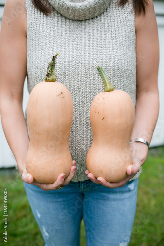 Woman holding two squash in her hands.