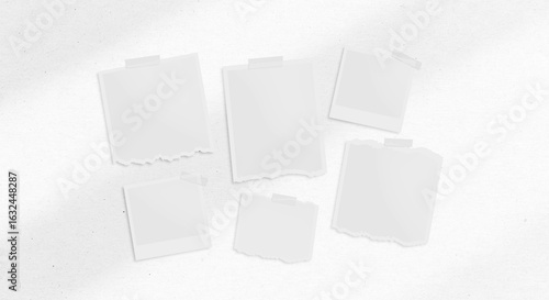 A Collection of Blank Instant Photo Frames and Torn Papers Taped on a White Background
