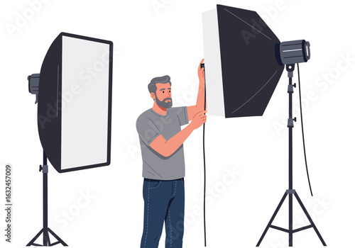 A man adjusting a softbox light setup standing between two lighting rigs in a studio setting