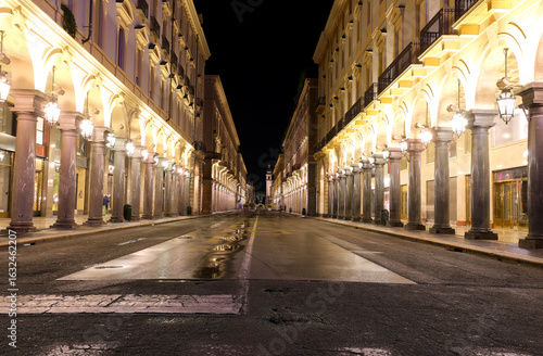night view of fashionable shopping street without people with buildings in northern italy
