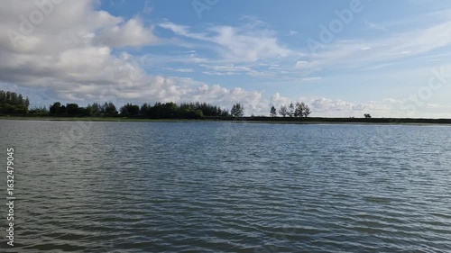 A tranquil body of water under a sky dotted with a few fluffy clouds 4k video