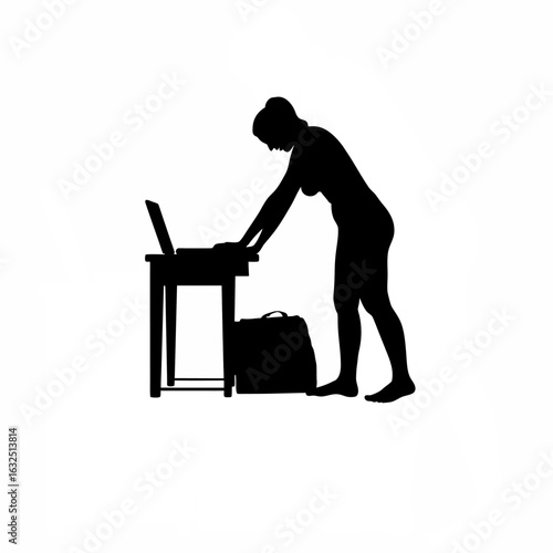 Silhouette of person opening laptop bag at workstation in early morning light