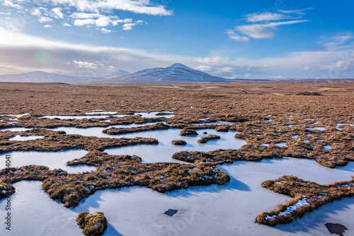Photos Winter frozen peat bog landscape with snow and mountains