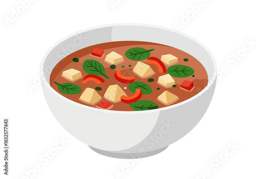 A white bowl filled with soup containing tofu spinach and red peppers