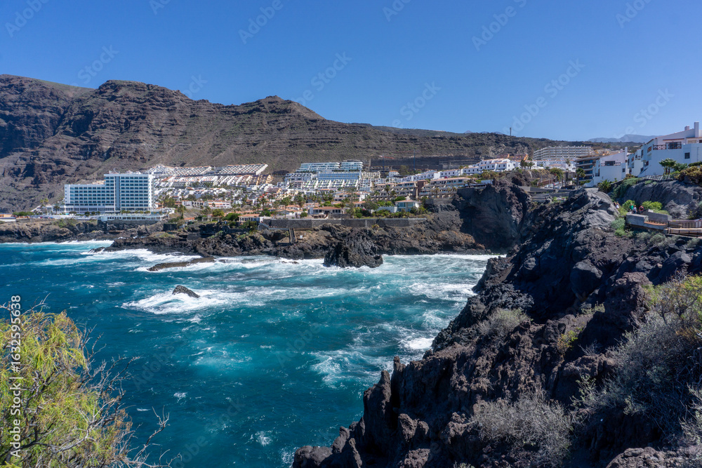 Obraz premium View of Los Gigantes Tourist City in Tenerife, Canary Islands, Surrounded by Ocean, Rocky Cliffs, and Vacation Architecture under the Bright Summer Sky