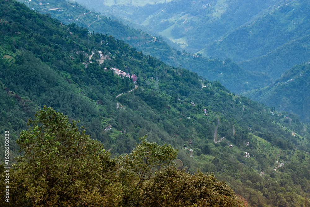 Fototapeta premium Scenic beauty of Green forests of Himalayan mountains, Okhrey, sikkim, India. Okhrey village is remote place in Sikkim where peaceful, tranquil Himalayan mountain range is enjoyed by tourists.