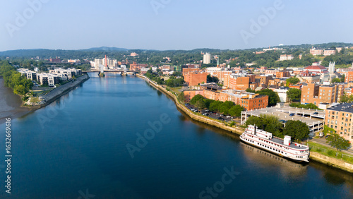 Quadro su tela Aerial view of historic downtown Troy, NY, at sunset with docked riverboat and v