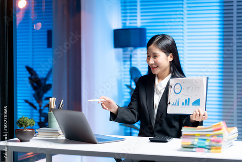 Presentation in the Digital Realm: A sophisticated professional, beaming with confidence, presents crucial data analysis from a laptop screen, embodying expertise in a modern office setting. 