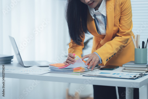 Fotografi Overwhelmed by Paperwork: A businesswoman grapples with a towering stack of docu