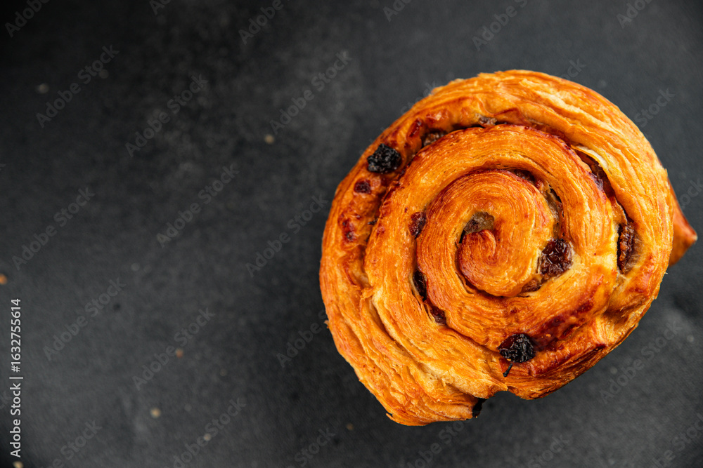 Obraz premium Raisin bun sweet pastry dessert puff pastry fresh delicious gourmet food background on the table rustic food top view copy space