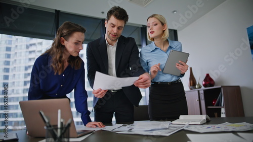 Quadro su tela Company colleagues planning budget reviewing financial papers at workplace