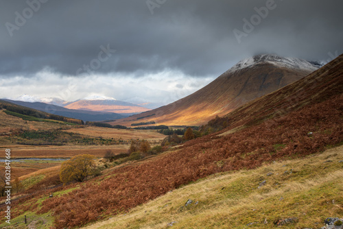Scottish mountains in autumn. First snow on the peaks. A spot of light on Beinn Dòrain. Between Tyndrum and Bridge of Orchy. Scotland, UK