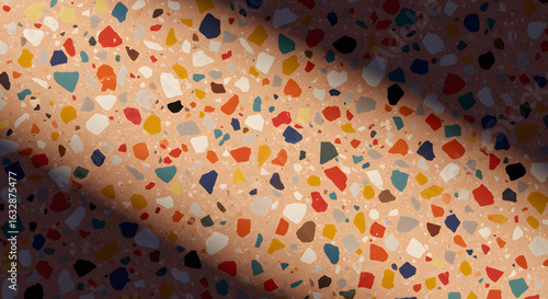 Detailed view of terrazzo flooring with a beam of light creating a contrast of color tones.
