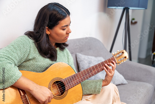 Φωτογραφία Singer songwriter composing new music playing acoustic guitar at home