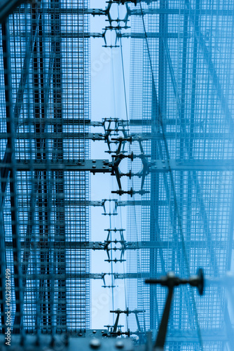 Geometric metal grid and framework with blue tones, viewed from below, creating a modern industrial pattern. Suitable for illustrating concepts of engineering, construction, architecture, or
