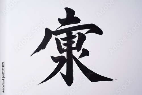 A large Japanese kanji character for longevity is written in black ink on a white background