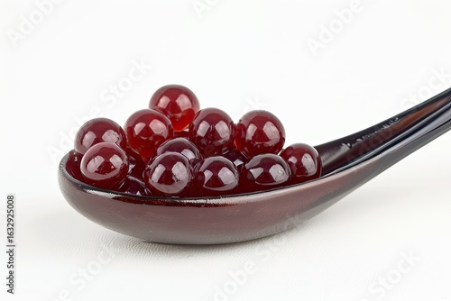 Red tapioca pearls for bubble tea isolated on white background. Tapioca pearls in ceramic spoon