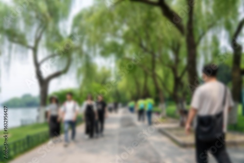 Wallpaper Mural Blurred image of a pathway lined with trees, with people walking through the greenery. Torontodigital.ca
