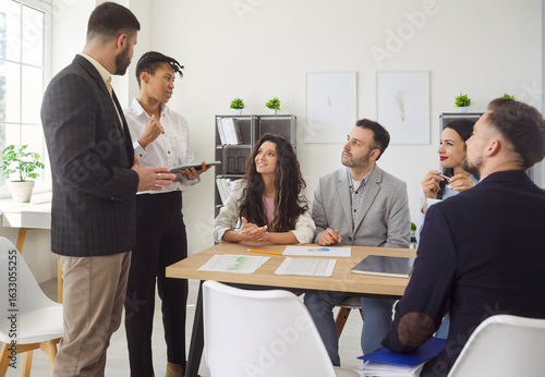 Billede på lærred Business people unite for meeting or presentation in office, strengthening company cooperation, infusing the workspace with a rhythm of work and teamwork among colleagues in a productive setting