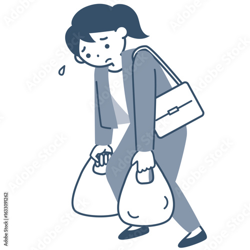 重い買い物袋を持って歩く若い女性