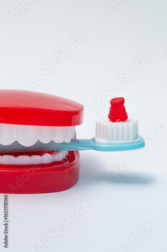 false teeth, a toothbrush and a red gummy bear