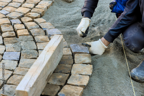 Konstfotografi Laborer is placing cobblestones meticulously while constructing path at worksite during works day