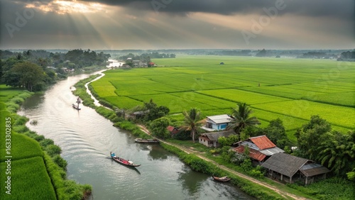Aerial view of a winding river through lush green rice paddies with a small boat and village