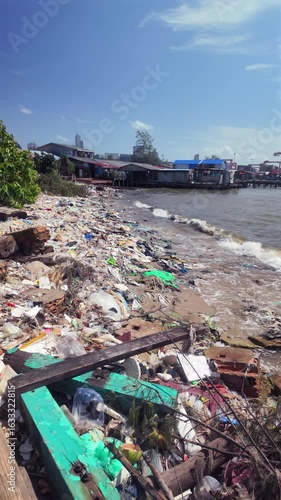 Wallpaper Mural Along the shore at Sihanoukville port, murky water languidly pushes a thick blanket of trash to the foot of waterside stilt houses, a scene that unfolds in slow motion. Torontodigital.ca